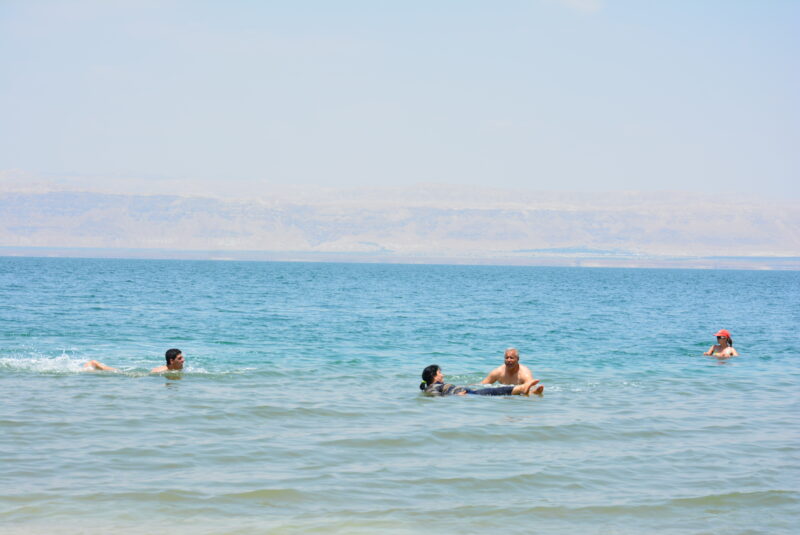 死海で湖水浴する人々。対岸はイスラエル