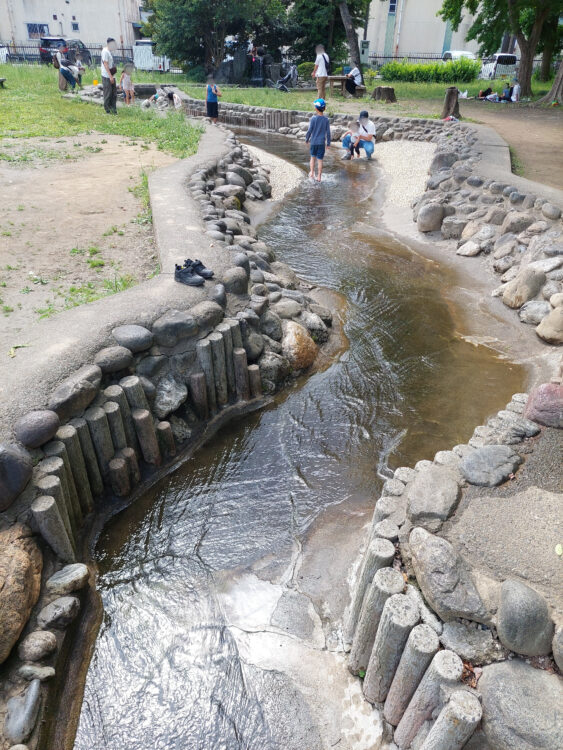 伊佐沼公園のじゃぶじゃぶ池で遊ぶ人々