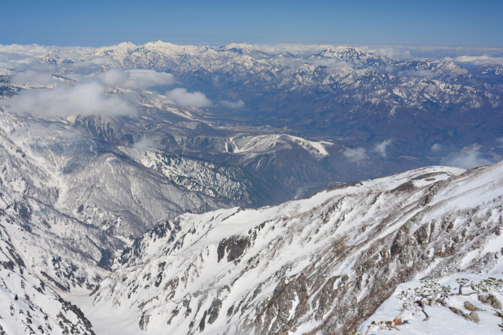 残雪期の唐松岳山頂から眺める上越の山々