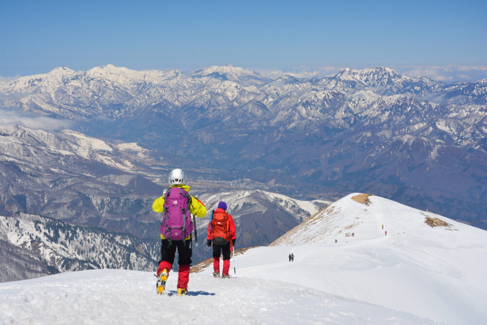 残雪期の唐松岳登山道を歩く登山者
