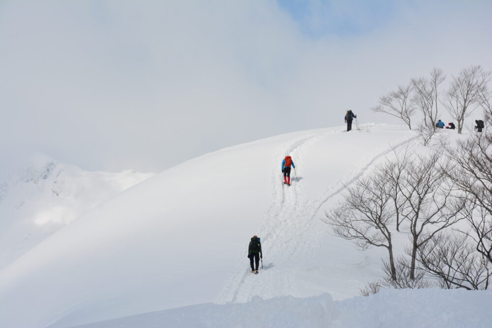 冬の谷川岳登山道を歩く登山者たち
