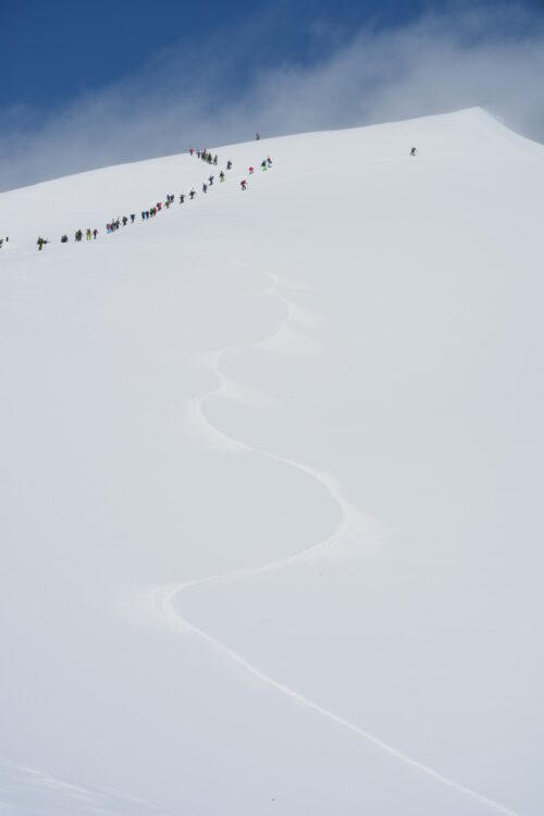 冬の谷川岳登山道を歩く登山者たちとシュプール