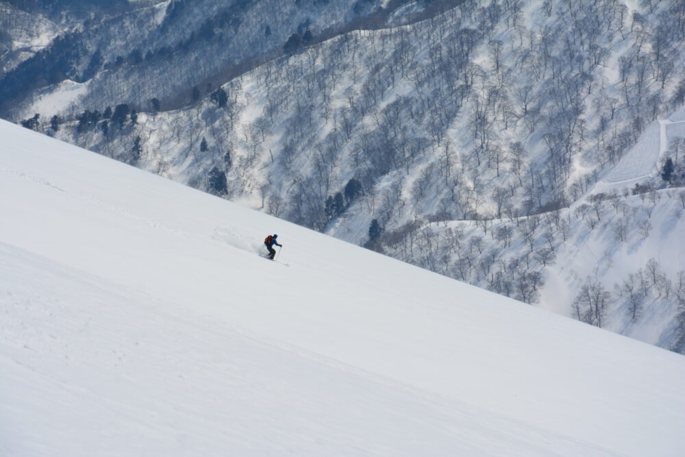 冬の谷川岳を滑走するスキーヤー