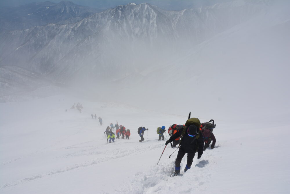 冬の谷川岳登山道を歩く登山者たち