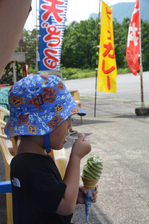 榛名山のお土産屋で抹茶アイスを食べる子供