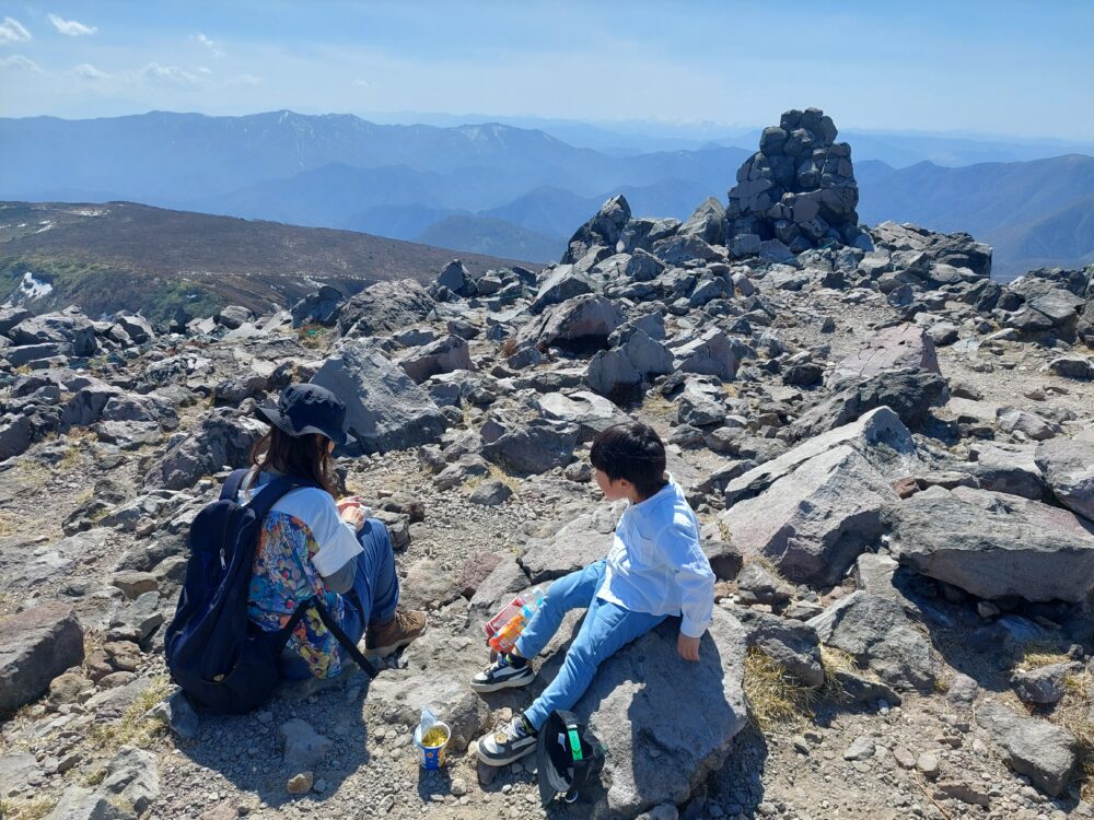 那須・茶臼岳の山頂で休む親子