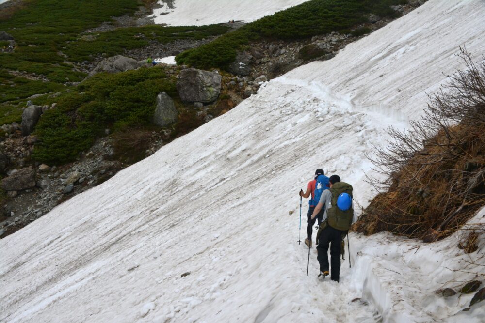 雪渓をトラバースする登山者
