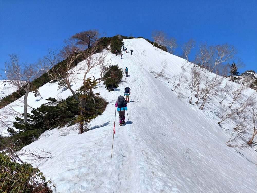残雪期の燕岳・合戦尾根を歩く登山者