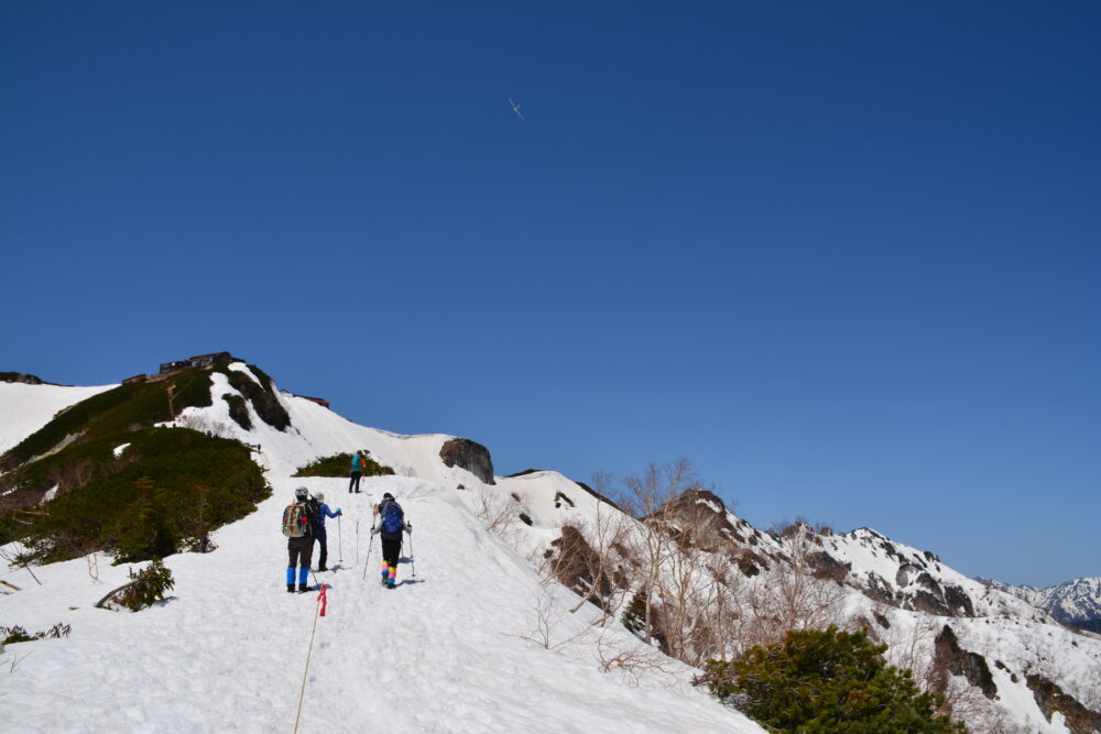残雪期の燕岳・合戦尾根を歩く登山者とドローン