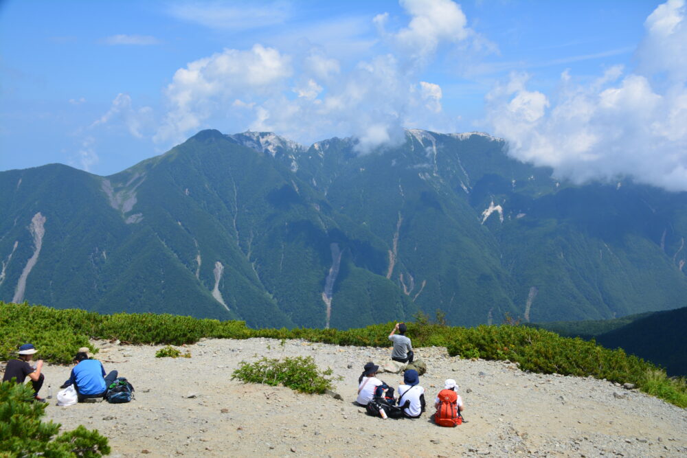 北岳で鳳凰三山を見ながら休憩してる登山者たち