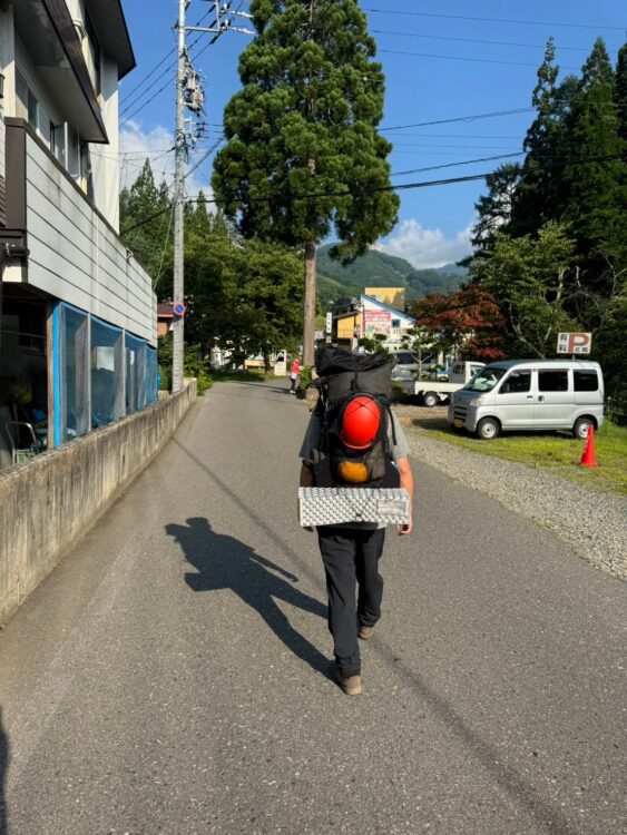 テント泊装備を担いで歩く登山者