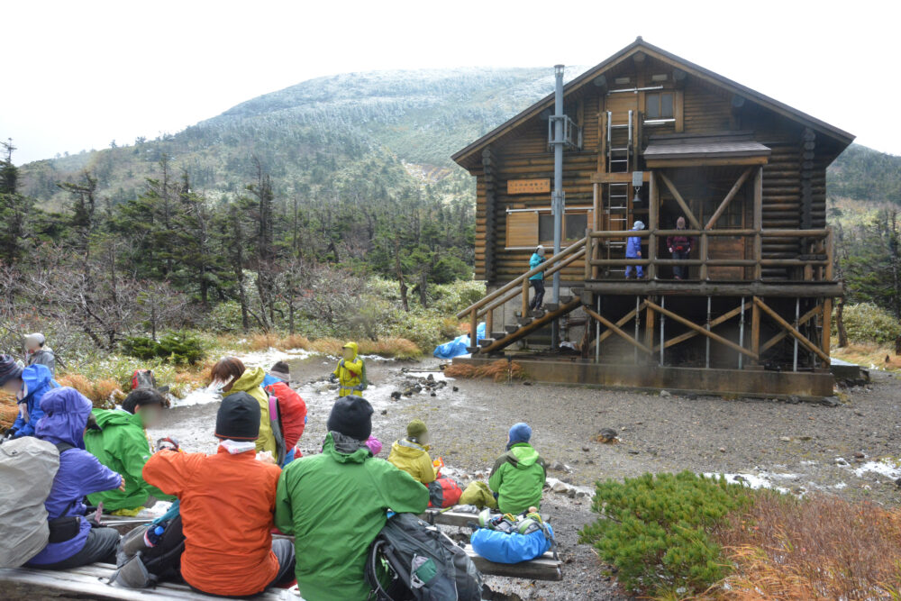 大岳鞍部避難小屋前で休憩する登山者たち