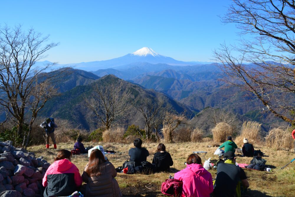 鍋割山山頂で富士山を見ながら休憩する登山者たち