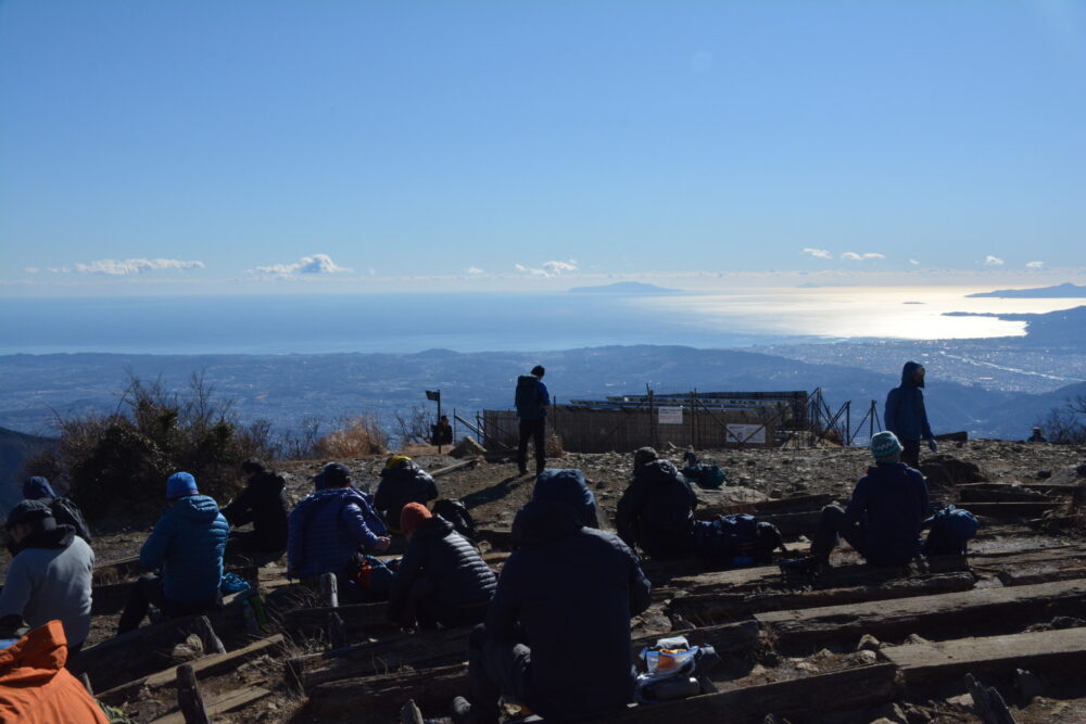 塔ノ岳山頂で相模湾を見ながらくつろぐ登山者たち