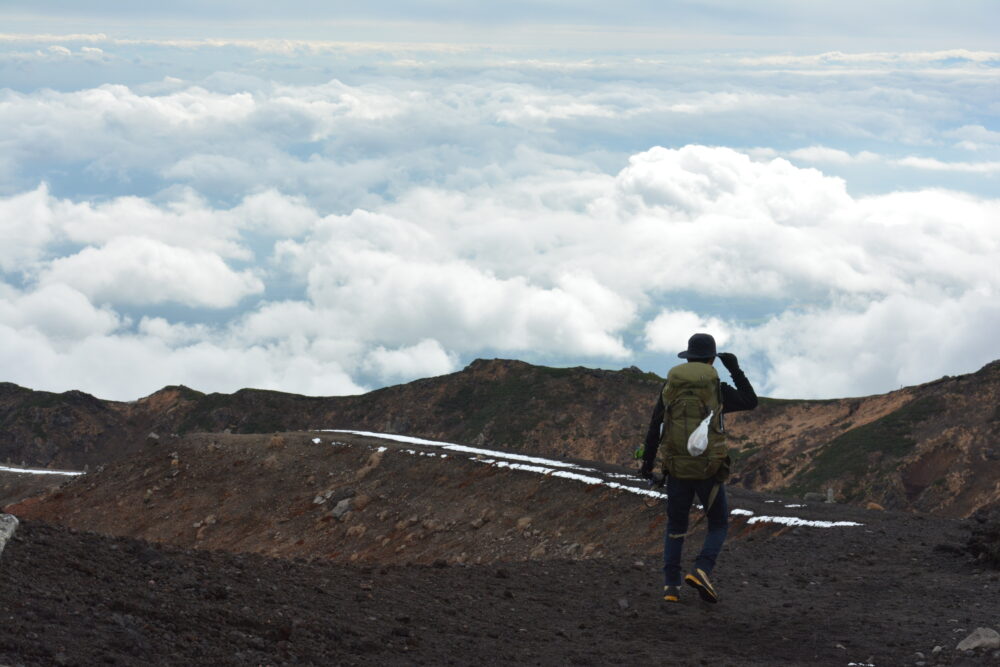 岩手山山頂を歩く登山者と雲海