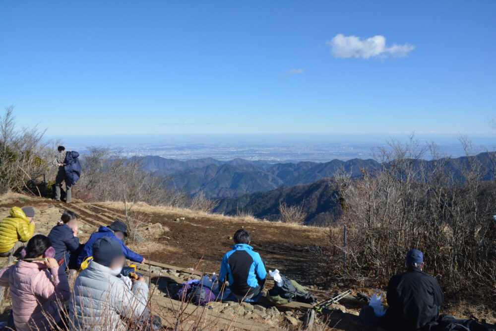 塔ノ岳山頂で関東平野を見ながらくつろぐ登山者たち