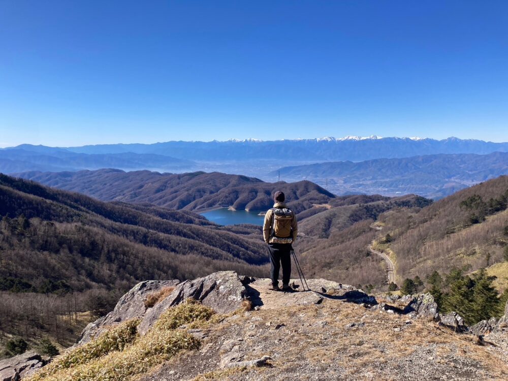 甲州アルプスから南アルプスを眺める登山者