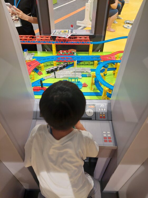 スマーク伊勢崎ファンビレッジwithトミカ・プラレール・リカちゃんのプレイコーナーにあるプラレールのレイアウトで遊ぶ子供