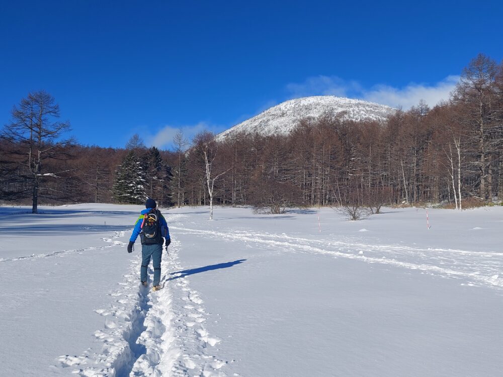 雪の湯ノ丸山山頂tお雪原を歩く登山者