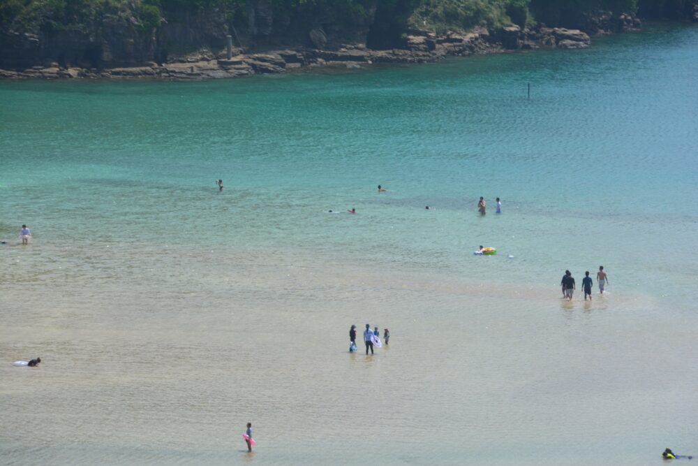 辰ノ島のビーチ裏手の丘から見た海水浴をする人たち