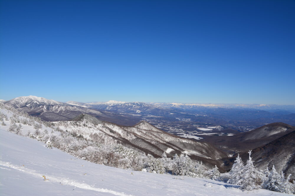 冬の湯ノ丸山山頂から見た草津方面の山並みと澄んだ青空