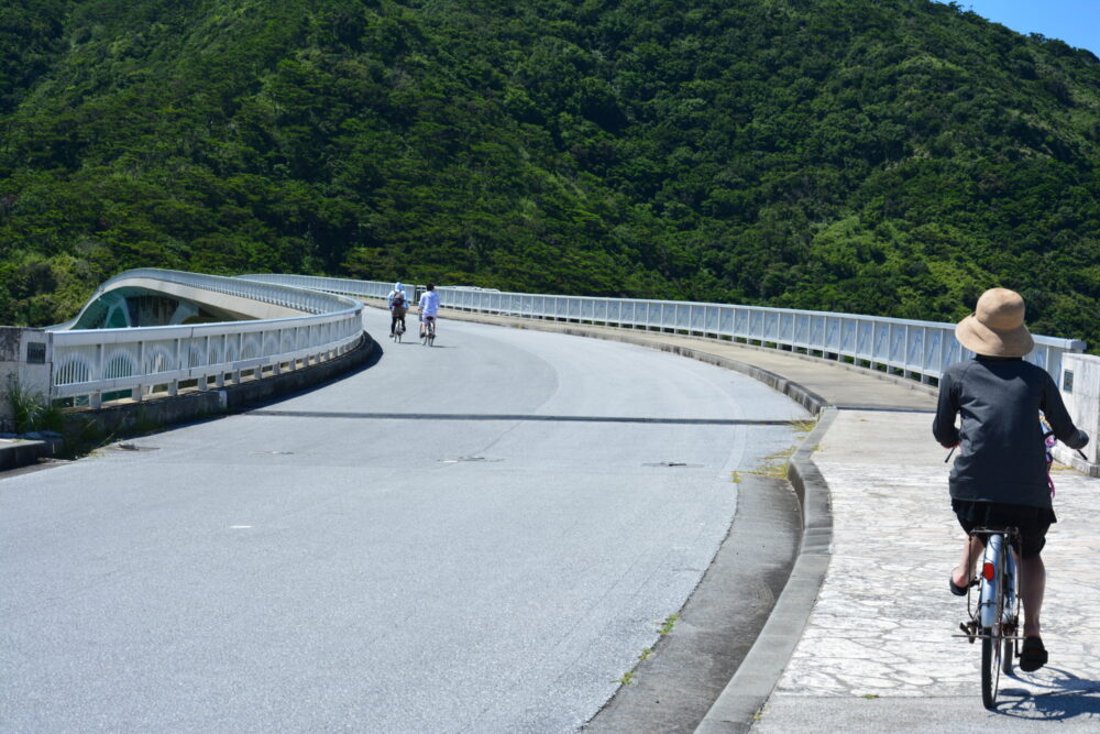 阿嘉大橋を自転車で渡る観光客