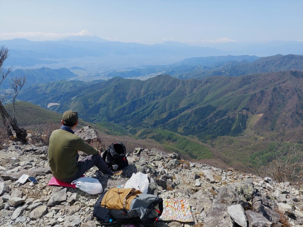 乾徳山で富士山を眺めながらランチする登山者