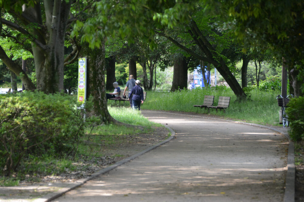 西城沼公園のウォーキングロードを歩く年配者