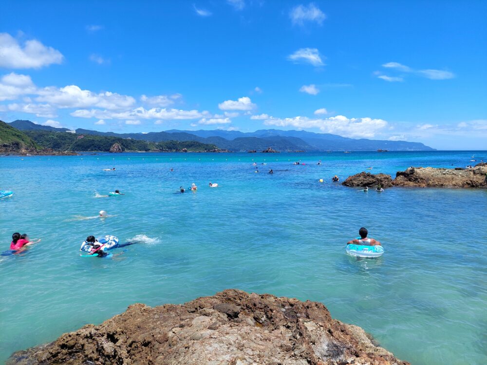 真夏の下田・九十浜海水浴場で海水浴やシュノーケリングをしている人たち