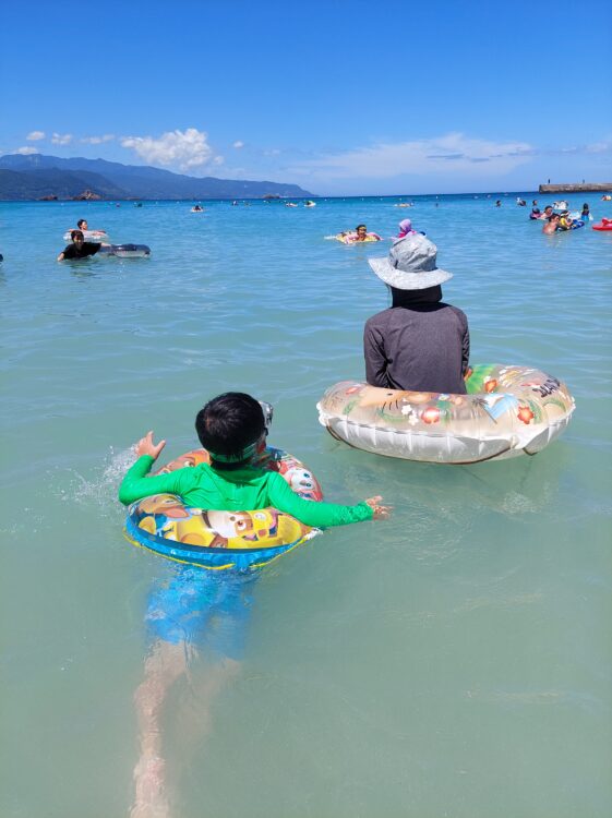真夏の下田・九十浜海水浴場で海水浴をしている親子