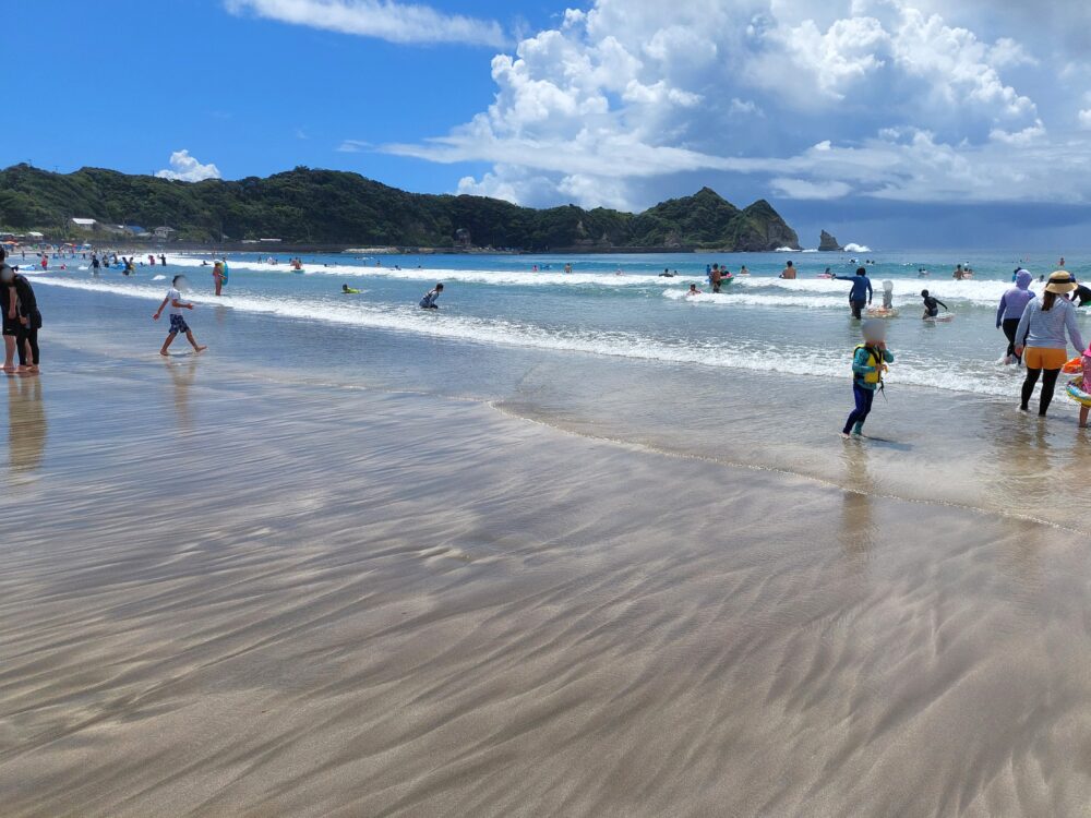 夏の鵜原海水浴場で水浴をしてる人々