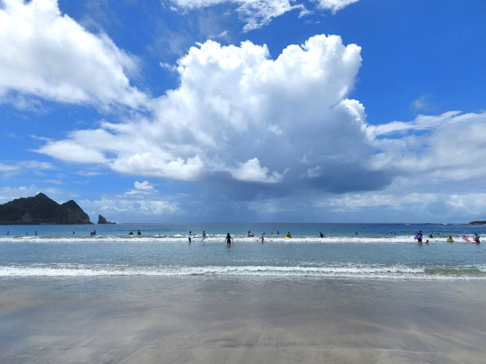 夏の鵜原海水浴場で海水浴をしてる人たちと夏雲
