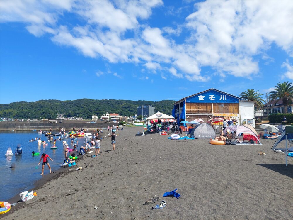 伊東市・オレンジビーチで海水浴をしてる人々と海の家
