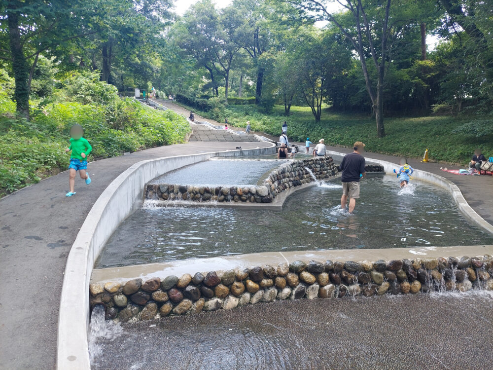 国営武蔵丘陵森林公園の水遊び場での下流で遊ぶ家族
