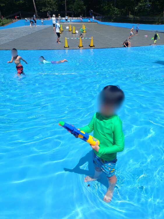 国営武蔵丘陵森林公園の水遊び場でウォーターガン(水鉄砲)を持つ子供