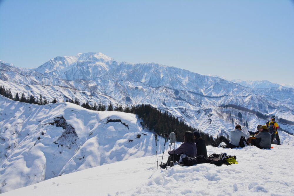 雪の大力山山頂で休憩している登山者たち