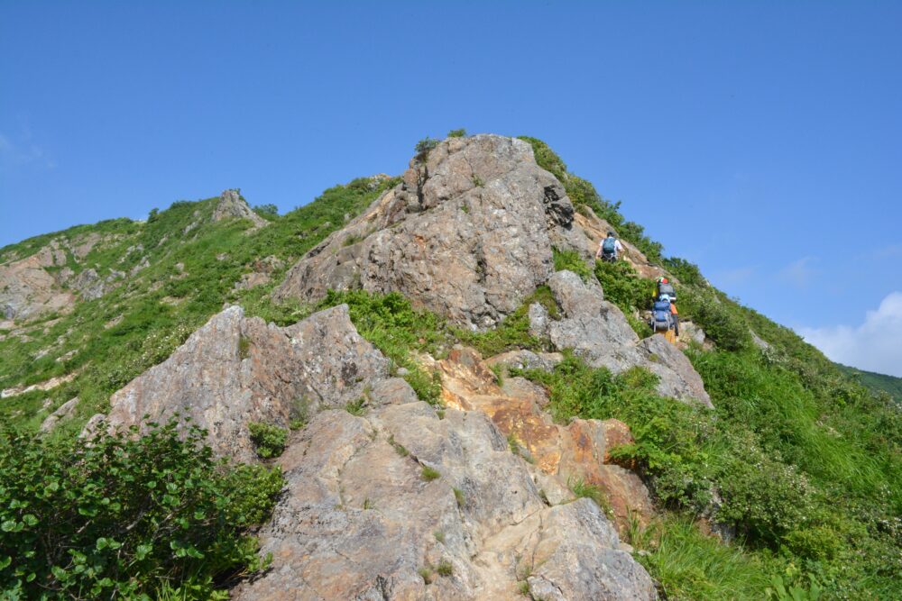 飯豊山の岩場を歩く登山者