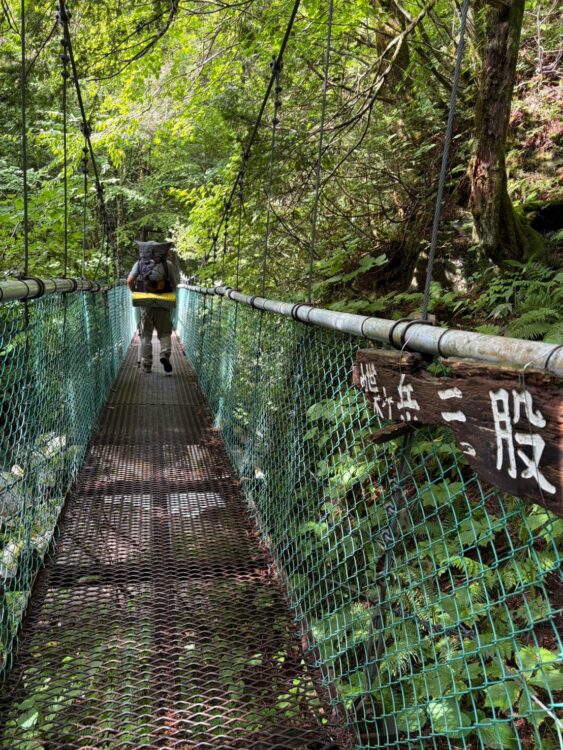 蝶ヶ岳の登山道にある橋を歩く登山者