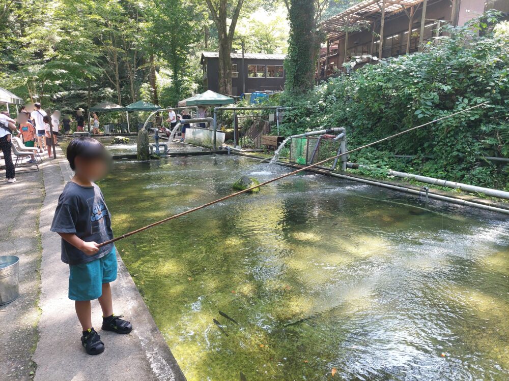 風布にじます釣り堀センターの釣り堀で釣りをする子供