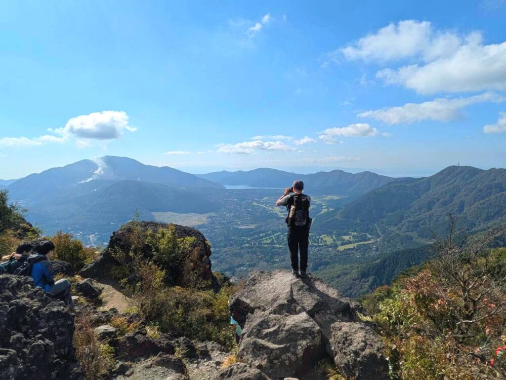 金時山山頂でカルデラの写真を撮る登山者